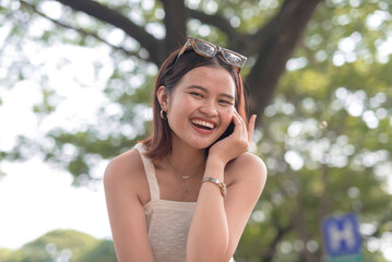 A carefree young Filipina poses for the camera with a wide smile while showing her wristwatch.