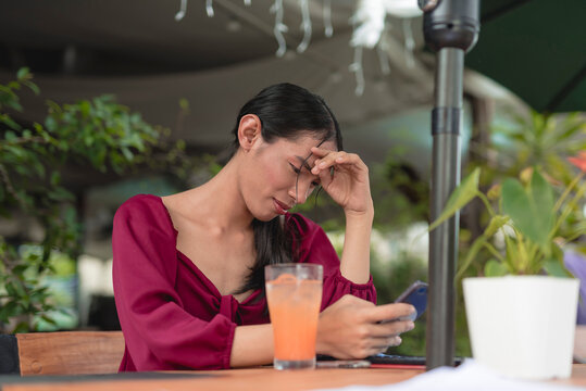 A pretty trans woman scrolls through her social media using her cellphone as she unwinds in a fancy coffee shop early in the morning.