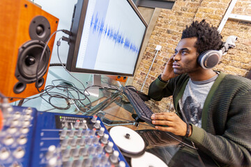 The Media Agency: Music Studio. An audio engineer at work editing in a recording studio - generic...