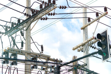 Three-phase electric power for transfer power by electrical grids. Electric power for support manufacturing industry. High voltage electric poles and wire lines against blue sky and white clouds.