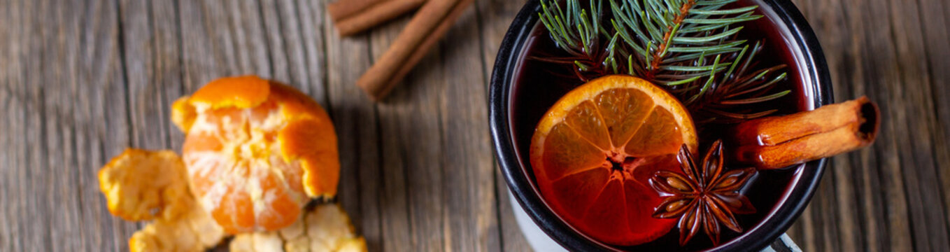 banner of Traditional tasty mulled wine hot drink with mandarin apple spices and christmas tree in white cup