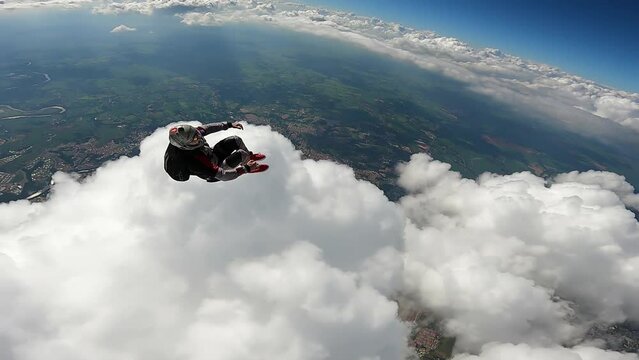 Skydiver turning and entering the clouds.