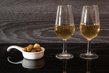 Dos copas de vino de jerez y aceitunas aliñadas