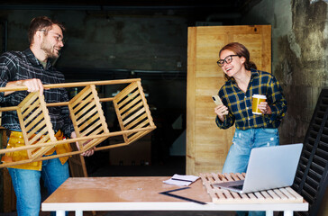 Woman and man having fun while working in their workshop family business concept.
