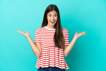 Young Brazilian woman isolated on blue background with shocked facial expression
