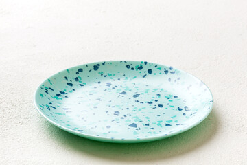 Perspective view of empty blue plate on cement background. Empty space for your design