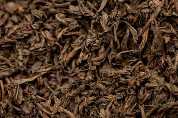 Large-leaved black tea in bulk on the table. Close-up of the surface texture