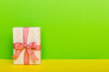 holiday paper present tied pink ribbon bow top view with copy space. Flat lay holiday background. Birthday or christmas present. Christmas gift box concept with copy space