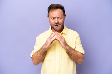 Middle age caucasian man isolated on purple background scheming something