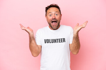 Middle age volunteer man isolated on pink background isolated on pink background with shocked...