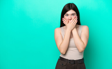 Young Russian woman isolated on green background covering mouth with hands