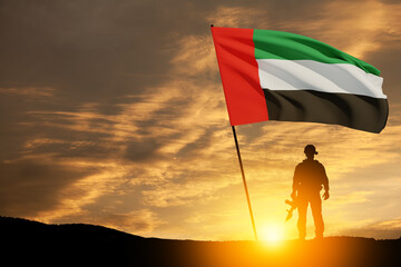 Silhouette of soldier with the flag of UAE against sunset or sunrise. Concept of national holidays. Commemoration Day.