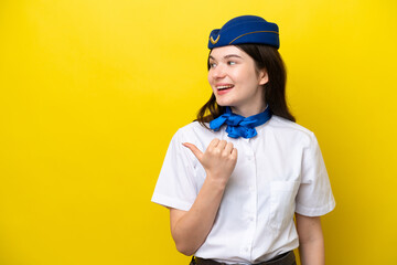 Airplane stewardess Russian woman isolated on yellow background pointing to the side to present a product