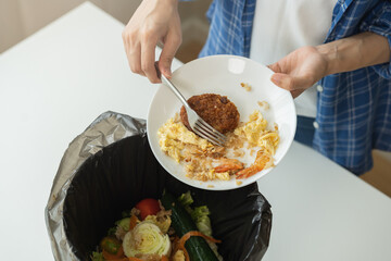 Compost from leftover food, refuse asian young housekeeper woman, girl hand using fork scraping waste from dish, throwing away putting into garbage, trash or bin..Environmentally responsible, ecology.