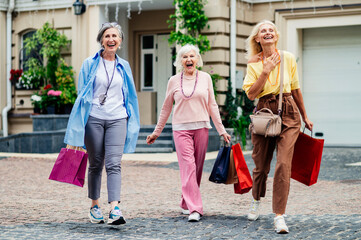 Beautiful happy senior women shopping in the city centre - Mature female adult friends with...
