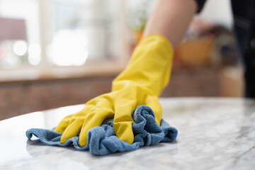 woman cleaning the table surface with towel and spray detergent - obrazy, fototapety, plakaty