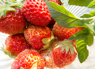 Beautiful photo  Fresh strawberry and green leaves  mint. Strawberry in the glass vase  Organic natural   art summer background  Selective focus