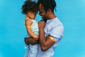 Peple gettig vaccine for covid-19 virus, vaccination against coronavirus - Black father and baby daughter getting vaccinated for coronavirus - obrazy, fototapety, plakaty