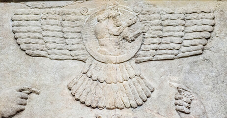 A Neo-Assyrian relief of Ashur as a feather robed archer holding a bow instead of a ring