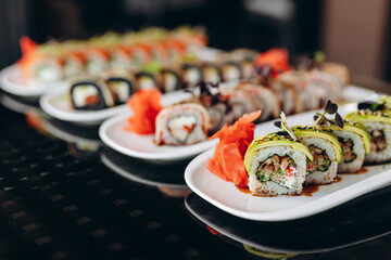 The table is served with four types of sushi with fish, eel, avocado and shrimp. Restaurant concept.