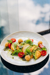 Roasted chicken with avocado and tomatoes in pesto sauce.