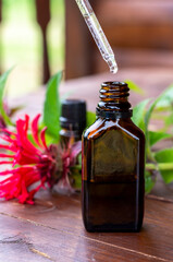 Essential oil of bergamot. Brown glass bottle, essential oil pipette and bergamot leaves on a wooden table.