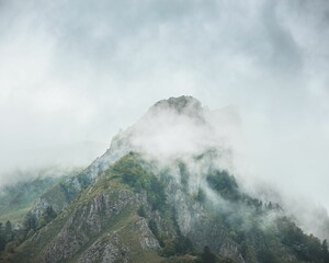 Beautiful scene of a high foggy mountain under vague sky