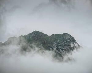 Beautiful scene of a high foggy mountain with vague gray sky, for wallpaper
