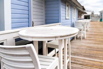 Seaside with empty chairs bar stools, round wooden tables in winter Florida Panhandle city town beach village with white blue architecture restaurant