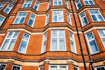 Residential apartment flats house building with many windows pattern in Gothic revival architecture...