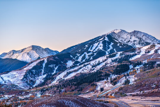 Aerial high angle view of ski resort town city of Aspen, Colorado after early winter snow on Buttermilk mountain with valley in autumn fall