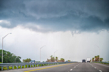 Interstate highway road 95 i95 near Daytona Beach, Florida with cars traffic by storm stormy gray blue clouds cloudy cloud cover