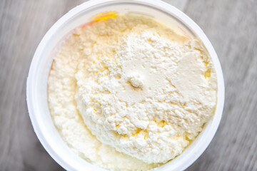 Macro closeup of Russian cottage farmer's cheese dairy milk tvorog cream homemade on wooden home kitchen table