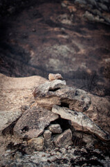 Signaling monolith on a road with burned fields in the background as a result of a fire, Zanbrana, Araba - Alava, Basque Country.
