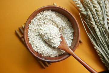 Close up of roasted oats flakes on spoon on table 