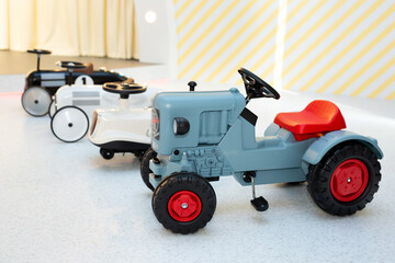 Small children's cars with pedals in the children's play area.