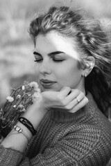 Obraz premium young curly girl in an orange sweater against the backdrop of autumn nature