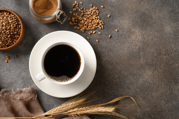 Organic barley coffee in white cup on brown background. Best natural caffeine free organic coffee alternative. Coffee substitute beverage made of a healthy blend of roasted barley. View from above - Powered by Adobe