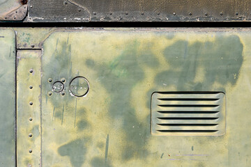 The exterior wall surface of the military helicopter is very old military green paint peeling off....