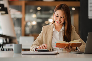 Fototapeta premium Happy smiling Asian businesswoman with laptop computer in modern office finance online accounting concept.