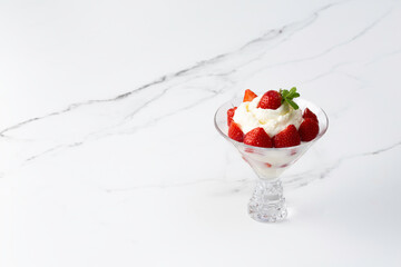 whipped cream with strawberries in a bowl on a light background