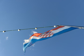 A Croatian flag in the wind on a boat that is sailing on the Adriatic Sea.