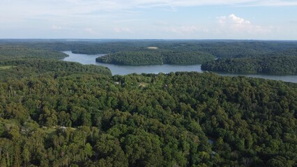 Aerial view of a lake surrounded by lush green dense forests