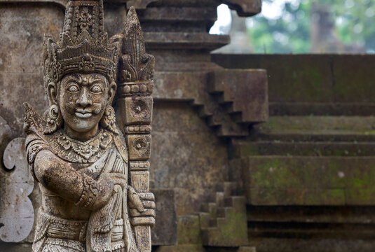 Traditional demon guards statue carved in stone in Hindu temple, Pura Tirta Empul, Bali, Indonesia