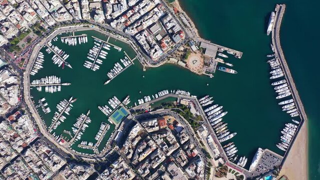 Aerial drone cinematic video of iconic port of Marina Zeas or Pasalimani with anchored yachts and sail boats as seen from high altitude, port of Piraeus, Attica, Greece