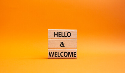 Hello and Welcome symbol. Concept words Hello and Welcome on wooden blocks. Beautiful orange background. Business and Hello and Welcome concept. Copy space. © Natallia
