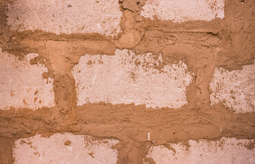 Abstract background from a brown wall made of blocks close-up.