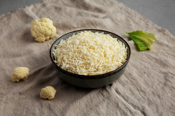 Organic Raw Cauliflower Rice in a Bowl, side view.