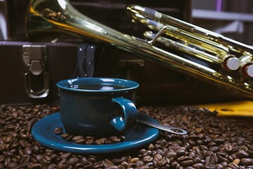 Coffee cup and coffee beans with a trumpet in the background