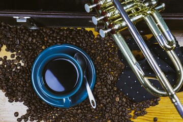 Coffee cup and coffee beans with a trumpet in the background
